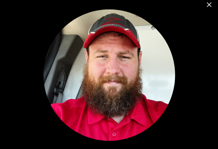 Man wearing a red cap and red shirt inside a vehicle