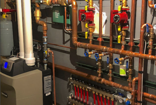 a traditional wall of in-floor heating plumbing with many manifolds, valves and joints